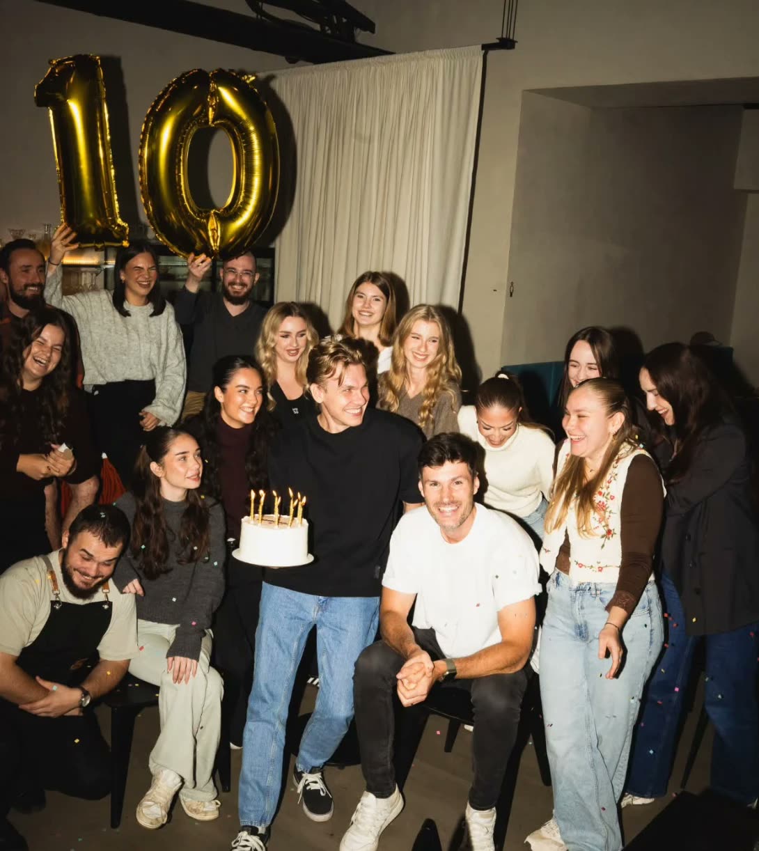 Tím Paddocku oslavuje 10. narodeniny, zlaté balóny s číslom 10 a torta so sviečkami.