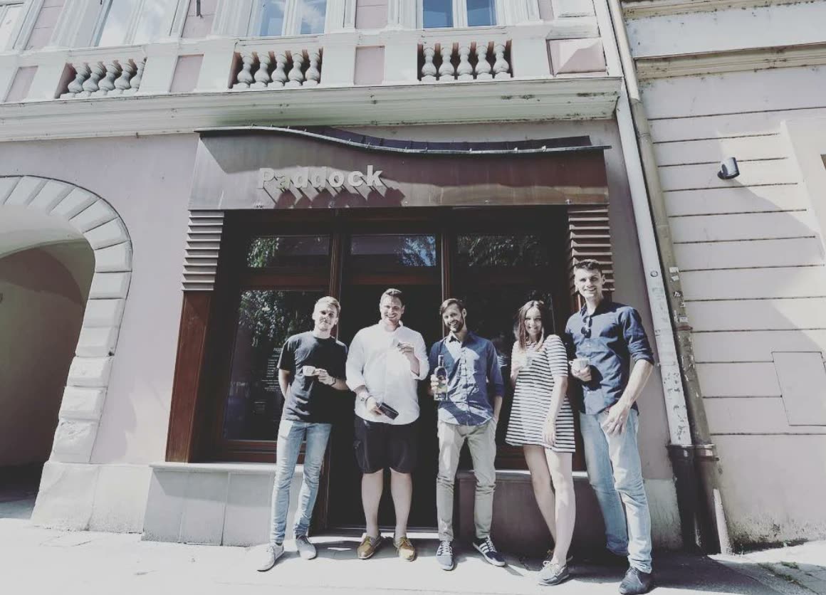 Päť ľudí s kávou v rukách stojí pred vchodom do starého Paddocku na Mierovom námestí.